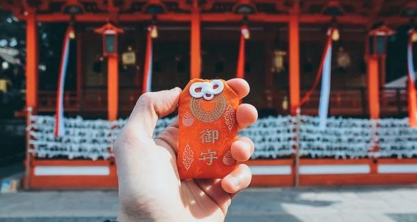 Holding an omamori at a shrine