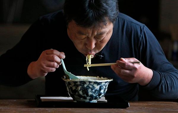 Man Slurping Noodles from a bowl