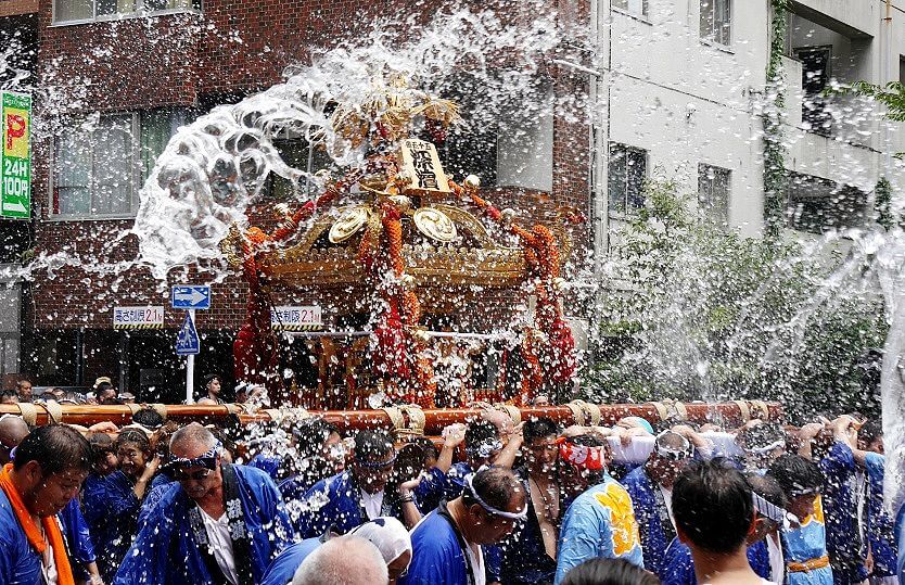 Spectators throwing water at the mikoshi carriers