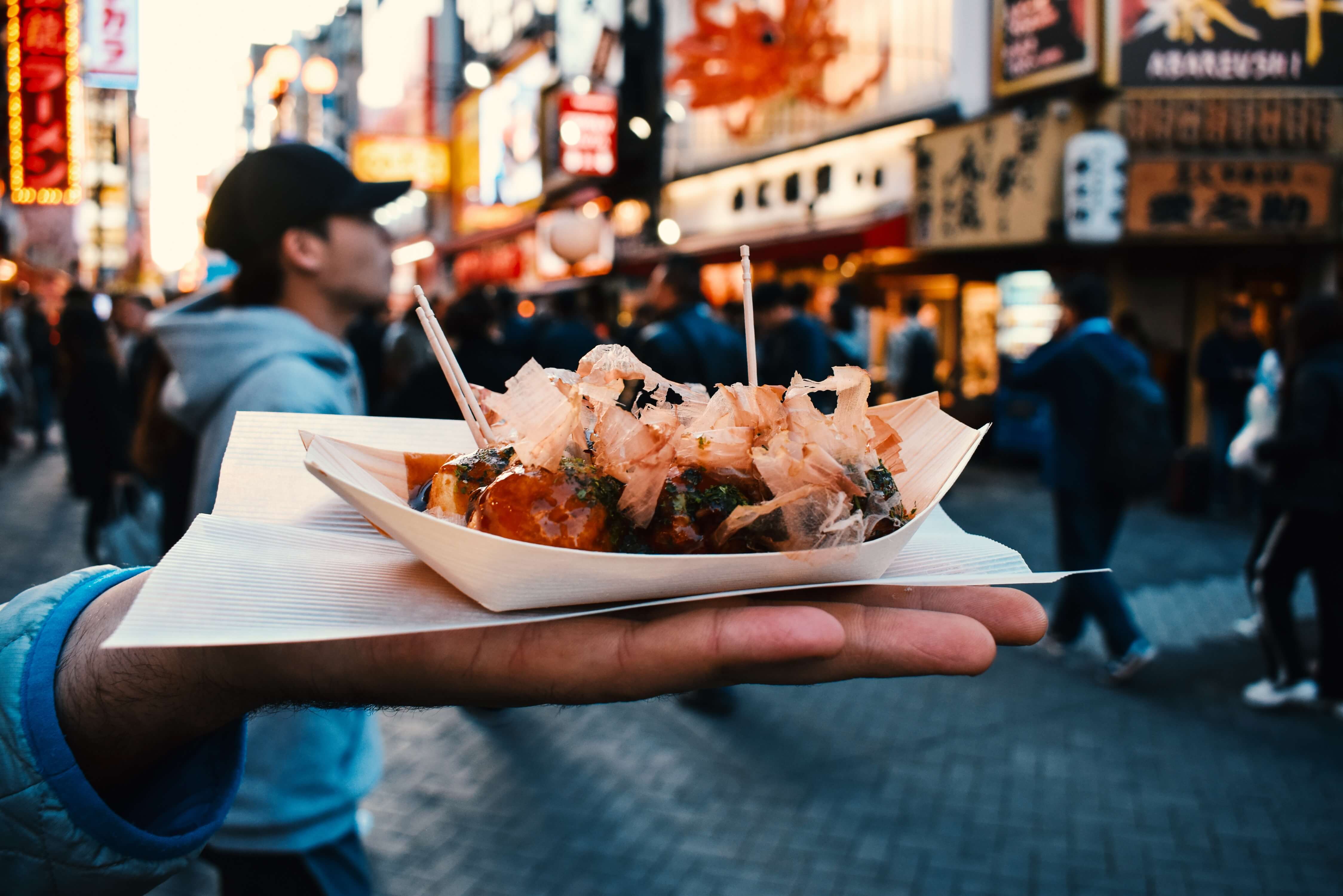 Eating takoyaki in Dotombori in Osaka